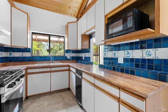 17651 Van Arsdale Rd, Potter Valley, CA 95469 - kitchen featuring black microwave, stainless steel gas range oven, vaulted ceiling, white cabinetry, and decorative backsplash