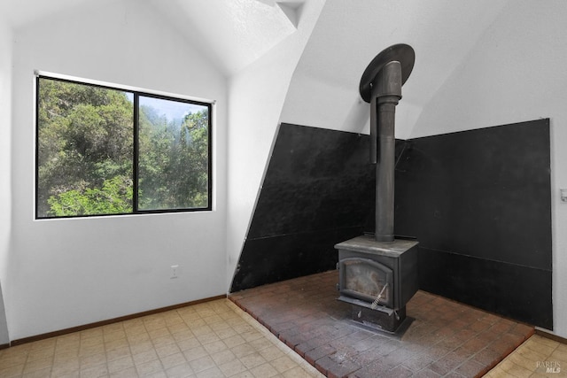 17651 Van Arsdale Rd, Potter Valley, CA 95469 - unfurnished living room featuring lofted ceiling, a wood stove, and baseboards