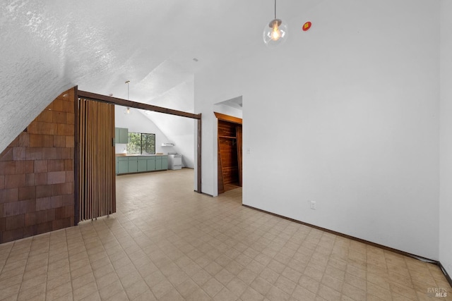 17651 Van Arsdale Rd, Potter Valley, CA 95469 - unfurnished living room featuring vaulted ceiling, tile patterned floors, and baseboards