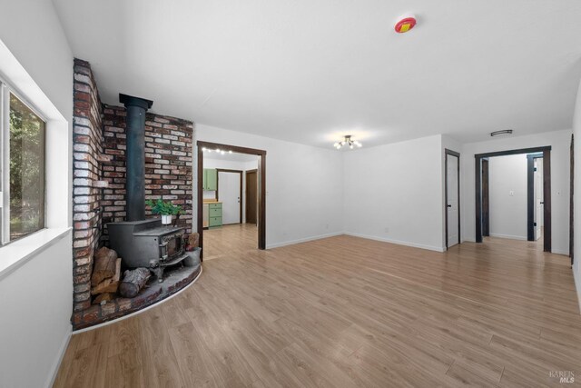17651 Van Arsdale Rd, Potter Valley, CA 95469 - living room with a wood stove, light wood-type flooring, and baseboards