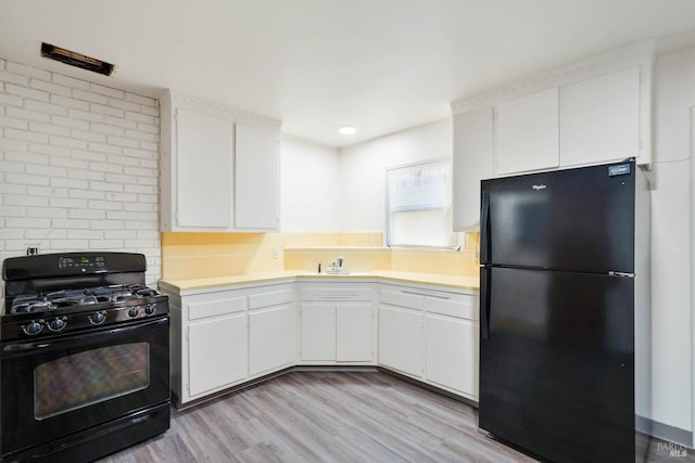 2409 Springs Rd, Vallejo, CA 94591 - kitchen featuring black appliances, light countertops, white cabinetry, light wood-type flooring, and a sink