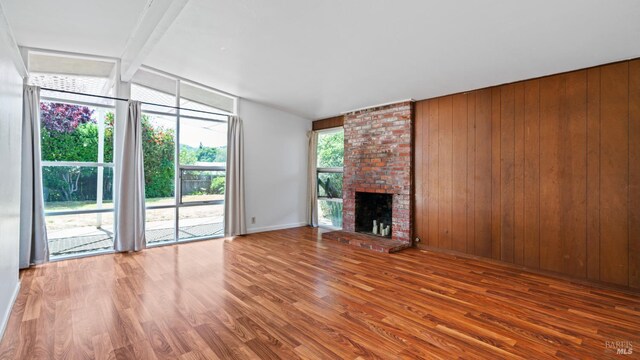 375 Las Colindas Rd, San Rafael, CA 94903 - unfurnished living room featuring wood finished floors, wood walls, a brick fireplace, and baseboards