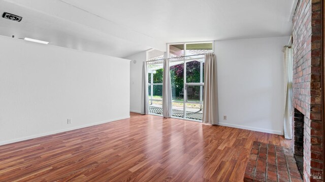 375 Las Colindas Rd, San Rafael, CA 94903 - unfurnished living room with wood finished floors, a fireplace, vaulted ceiling, and baseboards