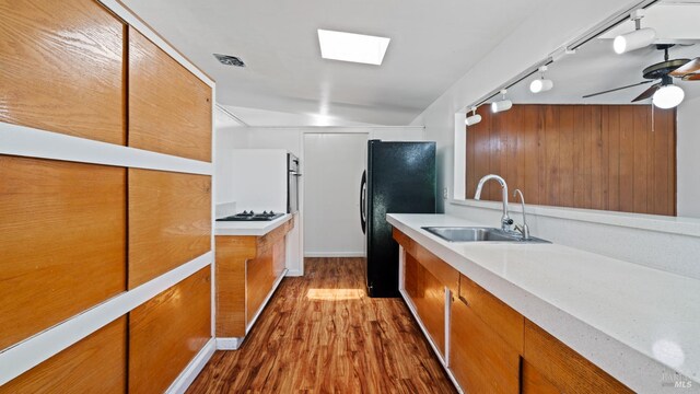 375 Las Colindas Rd, San Rafael, CA 94903 - kitchen featuring a sink, black appliances, brown cabinets, dark wood finished floors, and light countertops