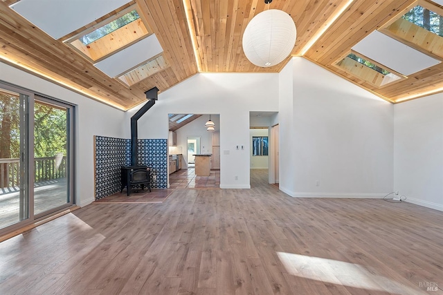 17075 Fitzpatrick Ln, Occidental, CA 95465 - unfurnished living room with a skylight, a wood stove, wooden ceiling, wood finished floors, and high vaulted ceiling