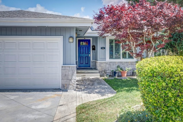 32 Romine Way, Vallejo, CA 94591 - property entrance featuring concrete driveway, stone siding, a garage, board and batten siding, and a shingled roof