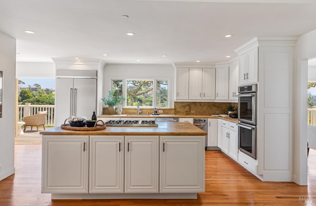 91 Round Hill Rd, Tiburon, CA 94920 - kitchen featuring appliances with stainless steel finishes, a center island, white cabinetry, tasteful backsplash, and recessed lighting