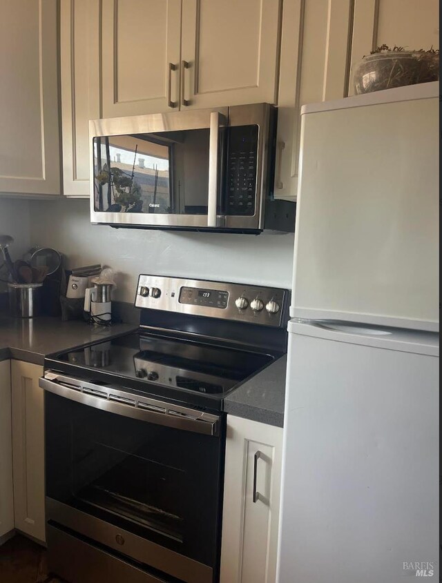 26 Fairfax Unit C, San Rafael, CA 94901 - kitchen with stainless steel appliances, white cabinets, and dark countertops