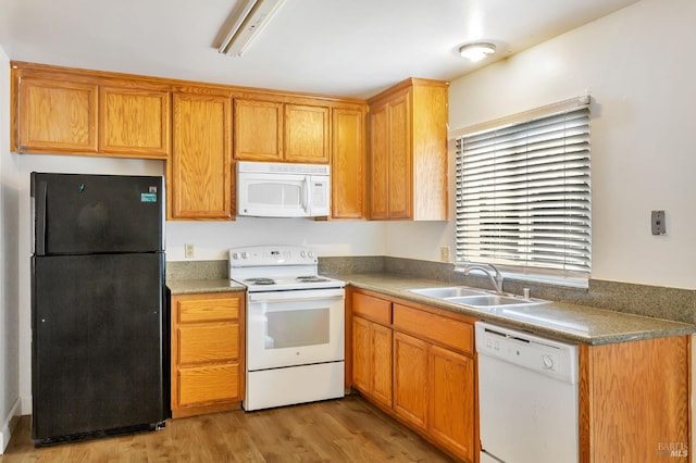 kitchen with white appliances, a sink, and light wood finished floors