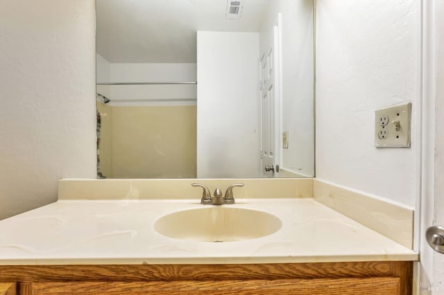 bathroom with vanity and a textured wall