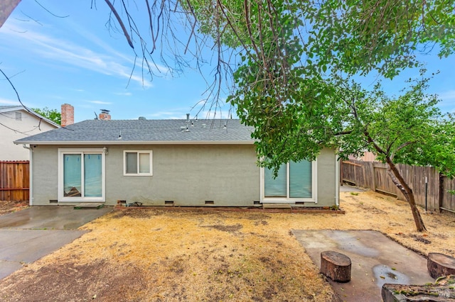 rear view of property with a fenced backyard, a patio area, a chimney, roof with shingles, and stucco siding