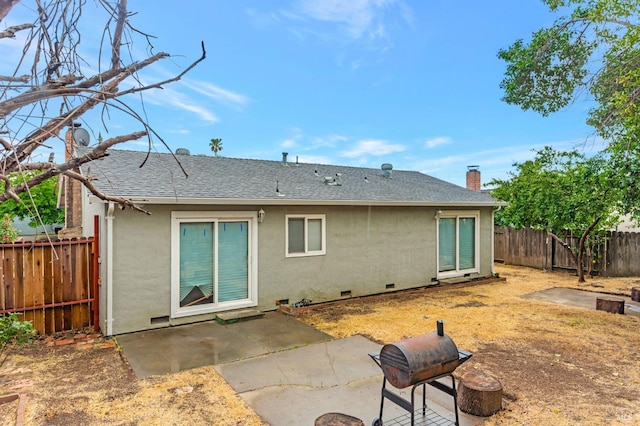 rear view of house featuring stucco siding, crawl space, a patio area, a fenced backyard, and roof with shingles