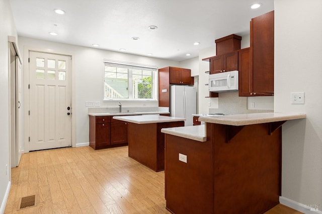 58 Randolph St, Napa, CA 94559 - kitchen with white appliances, a peninsula, light countertops, a sink, and a breakfast bar area