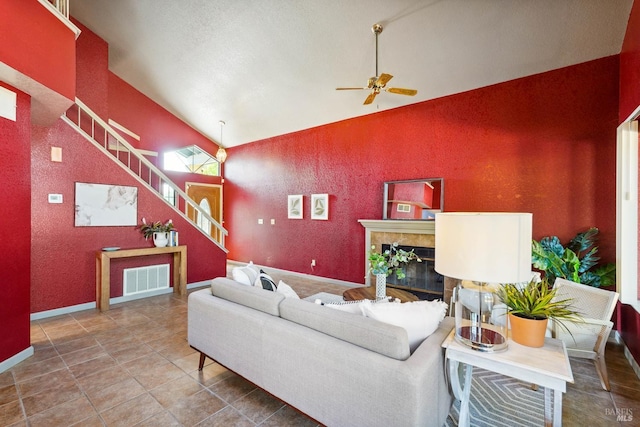 766 Morissette Way, Vacaville, CA 95687 - living room with a ceiling fan, stairs, a tiled fireplace, baseboards, and vaulted ceiling