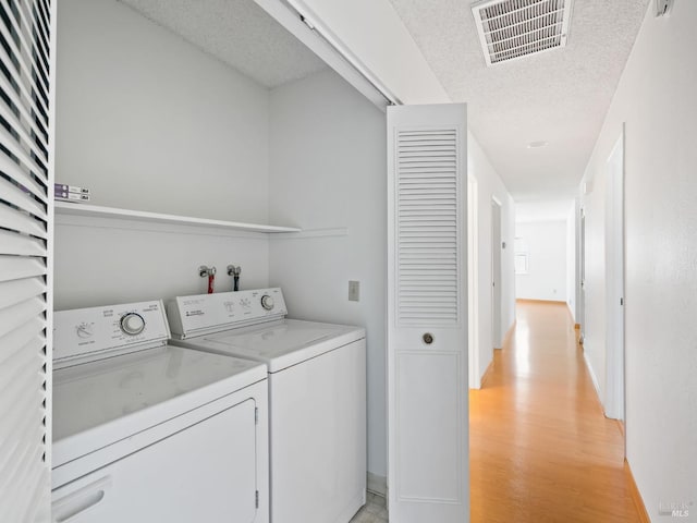 175 Temelec Cir, Sonoma, CA 95476 - clothes washing area featuring washer and clothes dryer, light wood-style floors, a textured ceiling, and baseboards
