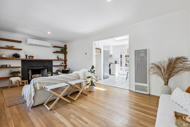 bedroom with a heating unit, a wall mounted AC, ornamental molding, light wood-style floors, and recessed lighting