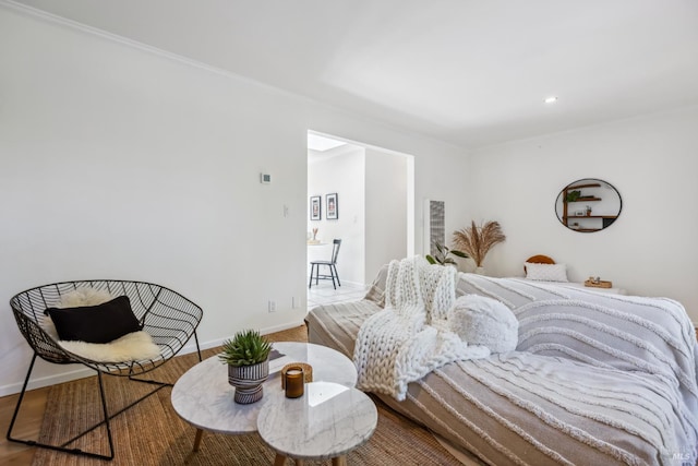 bedroom featuring wood finished floors, baseboards, and crown molding