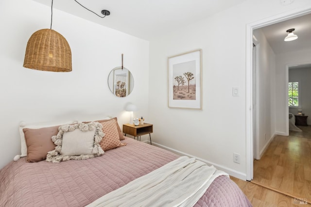 bedroom featuring light wood-style floors and baseboards