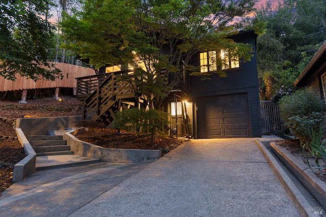 view of front of house with stairway, concrete driveway, and an attached garage