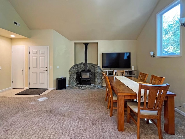 24034 Willow Ln, Willits, CA 95490 - dining room featuring a wood stove, vaulted ceiling, carpet flooring, and baseboards