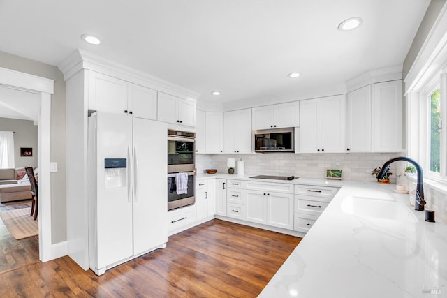 2812 Silver Fox Cir, Fairfield, CA 94534 - kitchen with appliances with stainless steel finishes, a sink, light stone counters, tasteful backsplash, and dark wood finished floors