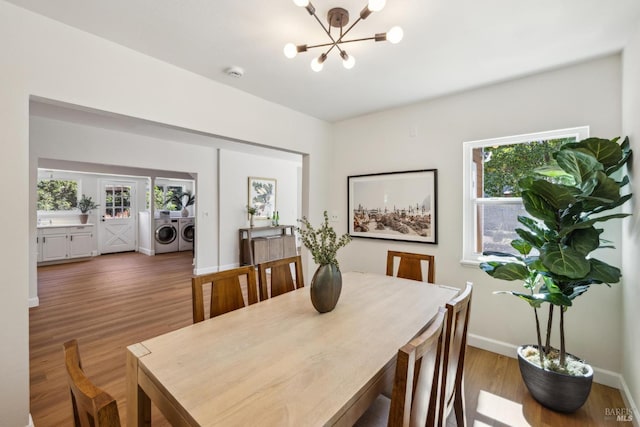 231 Railroad Ave, Woodacre, CA 94973 - dining space featuring washing machine and clothes dryer, a chandelier, healthy amount of natural light, and wood finished floors