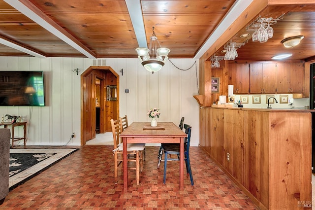 20215 Willow Rd, Monte Rio, CA 95462 - dining area featuring wood ceiling, brick patterned flooring, a chandelier, wood walls, and bar with sink