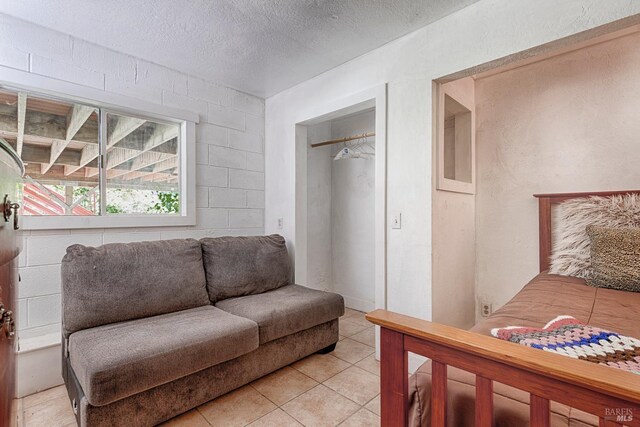 20215 Willow Rd, Monte Rio, CA 95462 - bedroom with light tile patterned flooring, a closet, and a textured ceiling