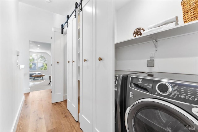 1358 Sylvan Ct, Healdsburg, CA 95448 - washroom with washing machine and dryer, light wood-style floors, and a barn door