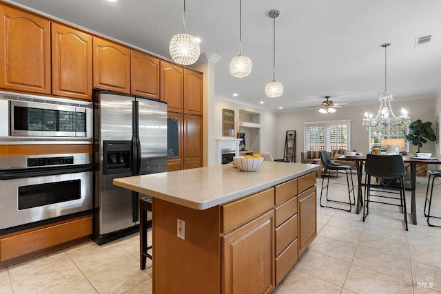 3704 Chapparal Ct, Fairfield, CA 94534 - kitchen with stainless steel appliances, ornamental molding, brown cabinets, light tile patterned floors, and a fireplace