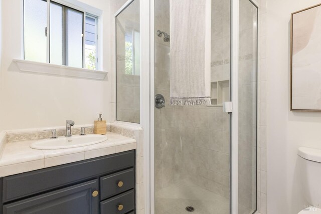 full bath featuring a stall shower, toilet, and vanity