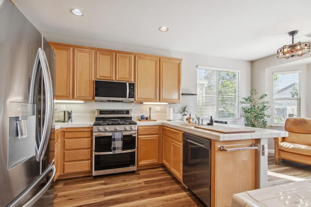 670 Turnberry Ter, Rio Vista, CA 94571 - kitchen with stainless steel appliances, tile countertops, a peninsula, light brown cabinetry, and recessed lighting
