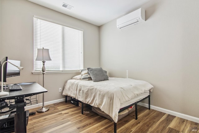 670 Turnberry Ter, Rio Vista, CA 94571 - bedroom with a wall mounted AC, light wood-style flooring, and baseboards