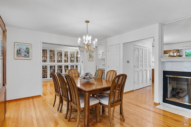 607 Tobin Dr, Vallejo, CA 94589 - dining room with a chandelier, light wood finished floors, a fireplace with flush hearth, and baseboards