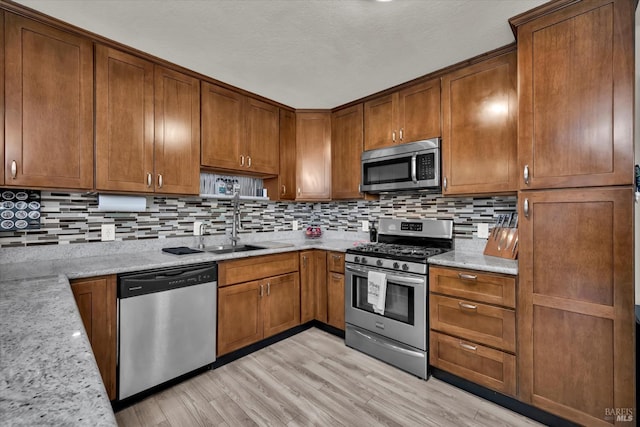 2298 Janette Dr, Napa, CA 94558 - kitchen with appliances with stainless steel finishes, a sink, light wood-type flooring, and brown cabinets