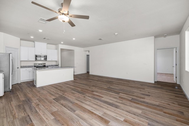 4404 Santa Fe St, Riverbank, CA 95367 - kitchen with stainless steel appliances, open floor plan, a sink, a ceiling fan, and wood finished floors