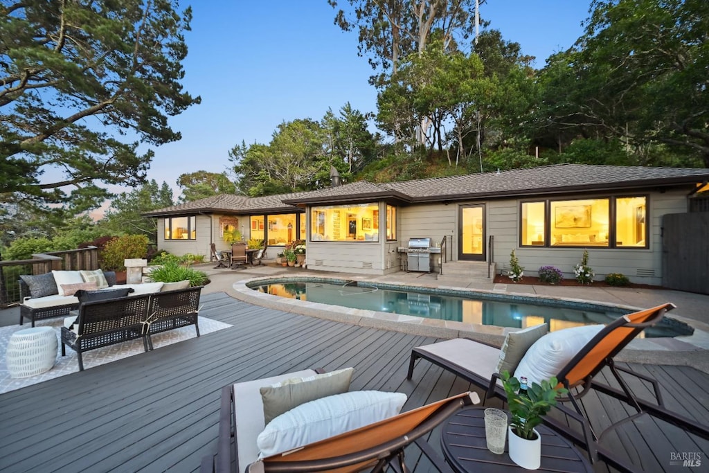 510 Redwood Rd, San Anselmo, CA 94960 - back of property at dusk with a wooden deck, outdoor lounge area, an outdoor pool, and outdoor dining area