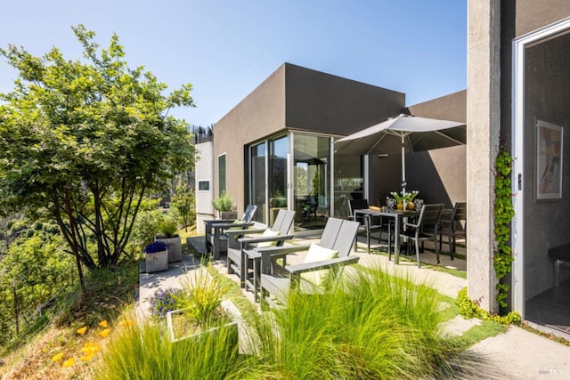 8909 Mill Creek Rd, Healdsburg, CA 95448 - back of house featuring stucco siding, outdoor dining space, and a patio area