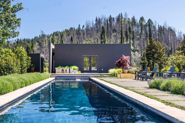 8909 Mill Creek Rd, Healdsburg, CA 95448 - swimming pool featuring a wooded view, french doors, and a patio