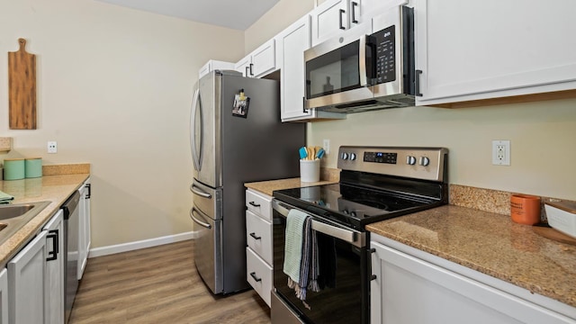 4200 E Commerce Way Unit 1324, Sacramento, CA 95834 - kitchen featuring appliances with stainless steel finishes, white cabinetry, light wood-type flooring, baseboards, and light stone countertops