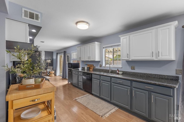 2835 Owens St, Fairfield, CA 94534 - kitchen with black appliances, white cabinetry, a sink, dark countertops, and light wood finished floors