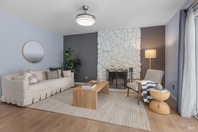 2835 Owens St, Fairfield, CA 94534 - living room with a stone fireplace, wood finished floors, baseboards, and an accent wall