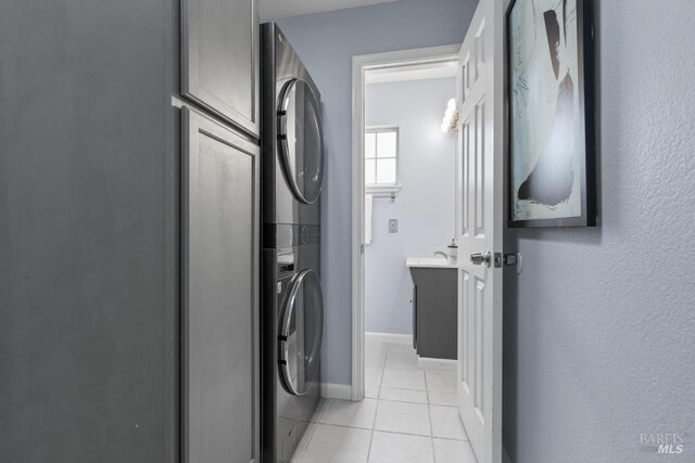 2835 Owens St, Fairfield, CA 94534 - washroom featuring estacked washer and dryer, light tile patterned floors, and baseboards