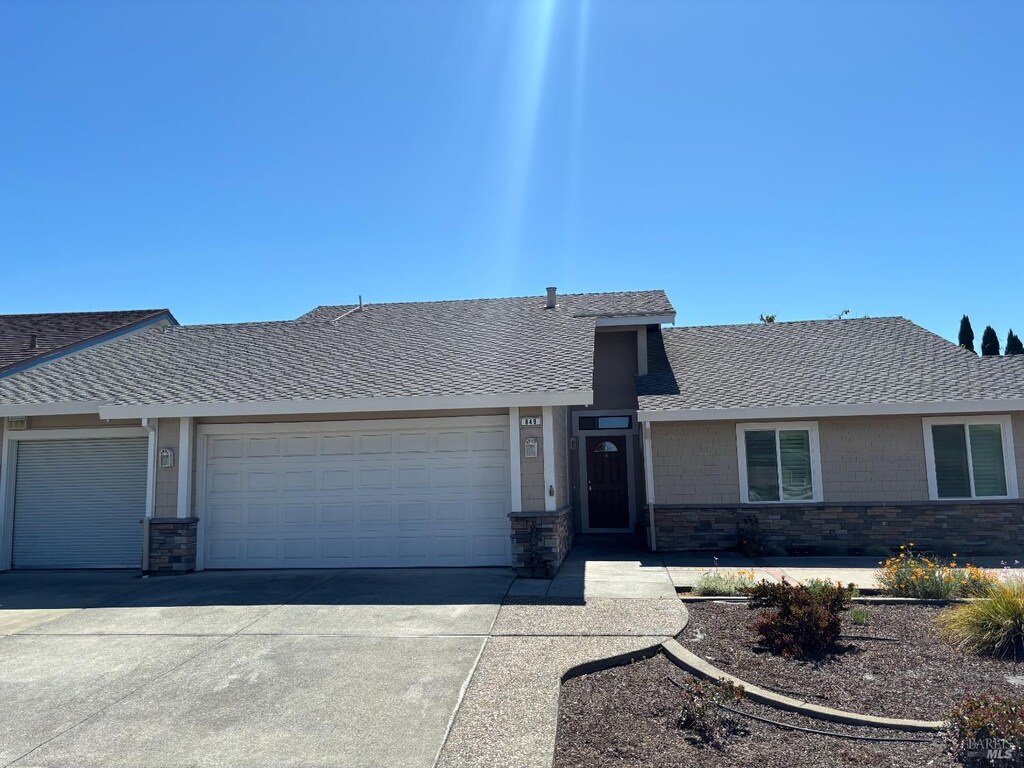 849 Clifton Ct, Benicia, CA 94510 - view of front of home with driveway, a garage, stone siding, and roof with shingles