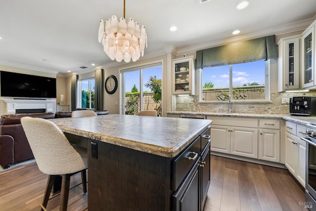 2056 Parsons Dr, Fairfield, CA 94533 - kitchen with ornamental molding, white cabinetry, open floor plan, a kitchen bar, and backsplash