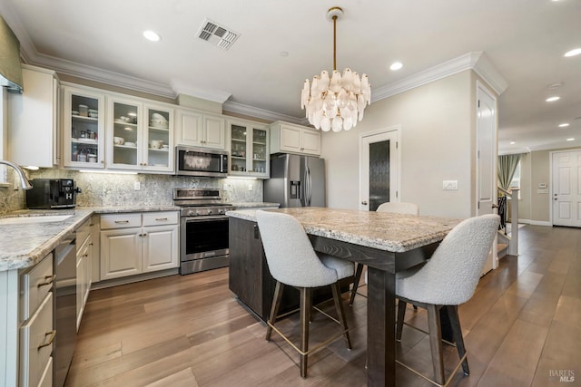 2056 Parsons Dr, Fairfield, CA 94533 - kitchen with stainless steel appliances, a sink, tasteful backsplash, a kitchen bar, and ornamental molding