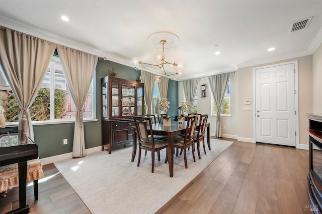 2056 Parsons Dr, Fairfield, CA 94533 - dining space with a chandelier, baseboards, crown molding, plenty of natural light, and light wood-style flooring