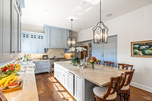 7035 Silverado Trl, Napa, CA 94558 - kitchen with stainless steel stove, a chandelier, dark wood-style flooring, tasteful backsplash, and a kitchen breakfast bar