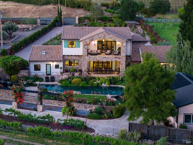 7035 Silverado Trl, Napa, CA 94558 - rear view of house with a tile roof, a balcony, stucco siding, stone siding, and a fenced backyard