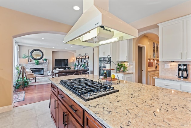 1261 Landmark Dr, Vallejo, CA 94591 - kitchen with stainless steel gas cooktop, light stone counters, white cabinets, decorative backsplash, and recessed lighting